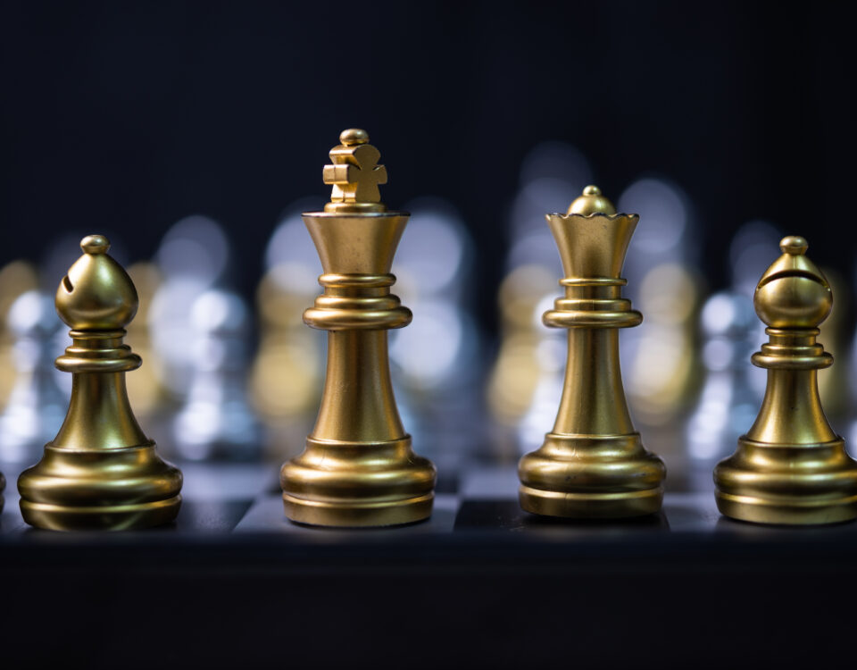 Goldene Schachfiguren auf einem Spielbrett – Symbol für Strategie, Planung und kluge Entscheidungen.