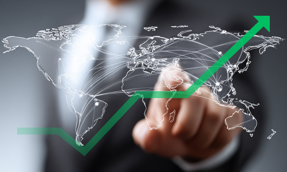 Geschäftsperson tippt auf eine digitale Weltkarte mit internationalen Verbindungslinien und steigender grüner Kurve; das Bild symbolisiert internationale Geschäftstätigkeit und Steueroptimierung für Unternehmer