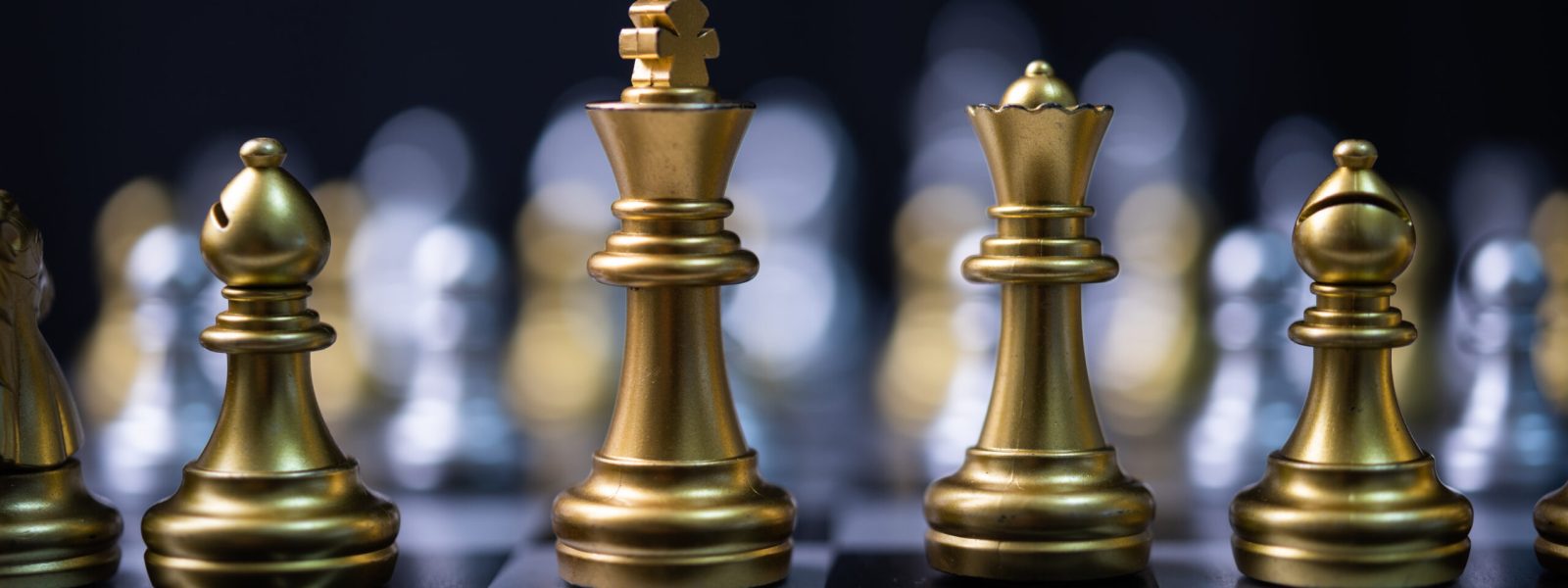 Goldene Schachfiguren auf einem Spielbrett – Symbol für Strategie, Planung und kluge Entscheidungen.