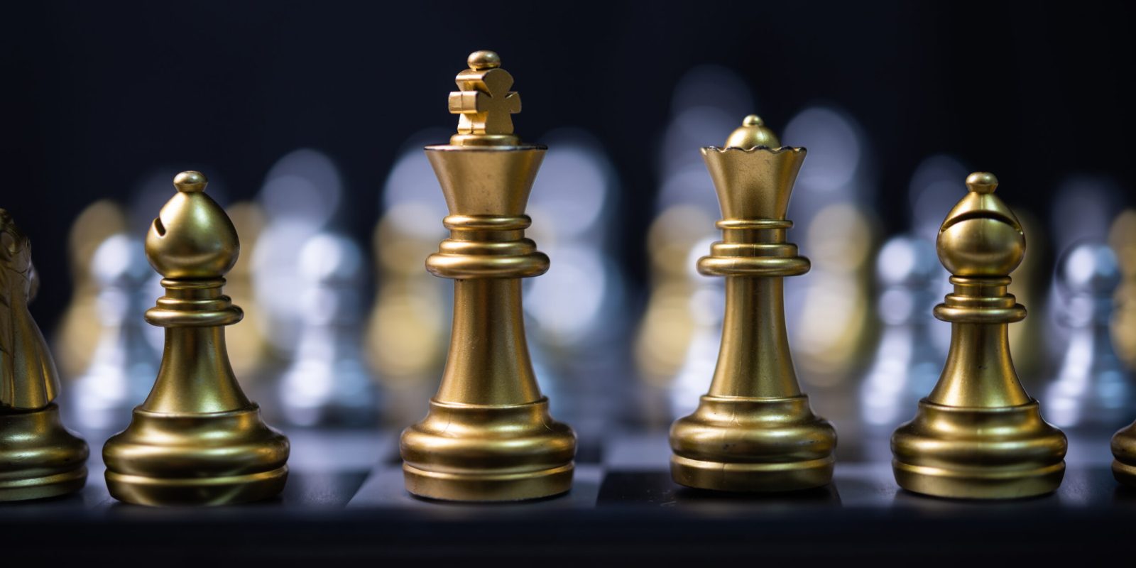 Goldene Schachfiguren auf einem Spielbrett – Symbol für Strategie, Planung und kluge Entscheidungen.