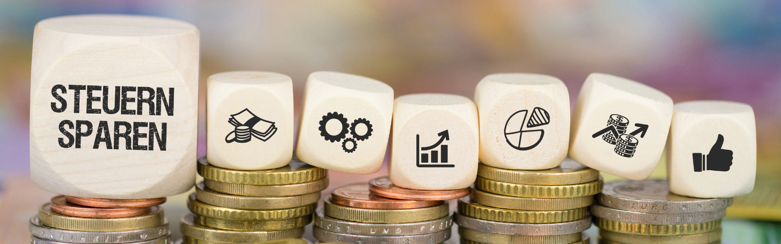 Holzwürfel mit der Aufschrift „Steuern sparen“ sowie Symbolen für Geld, Wachstum und Finanzplanung stehen auf gestapelten Münzen und veranschaulichen das Thema Steuern sparen als Selbstständiger & Freiberufler